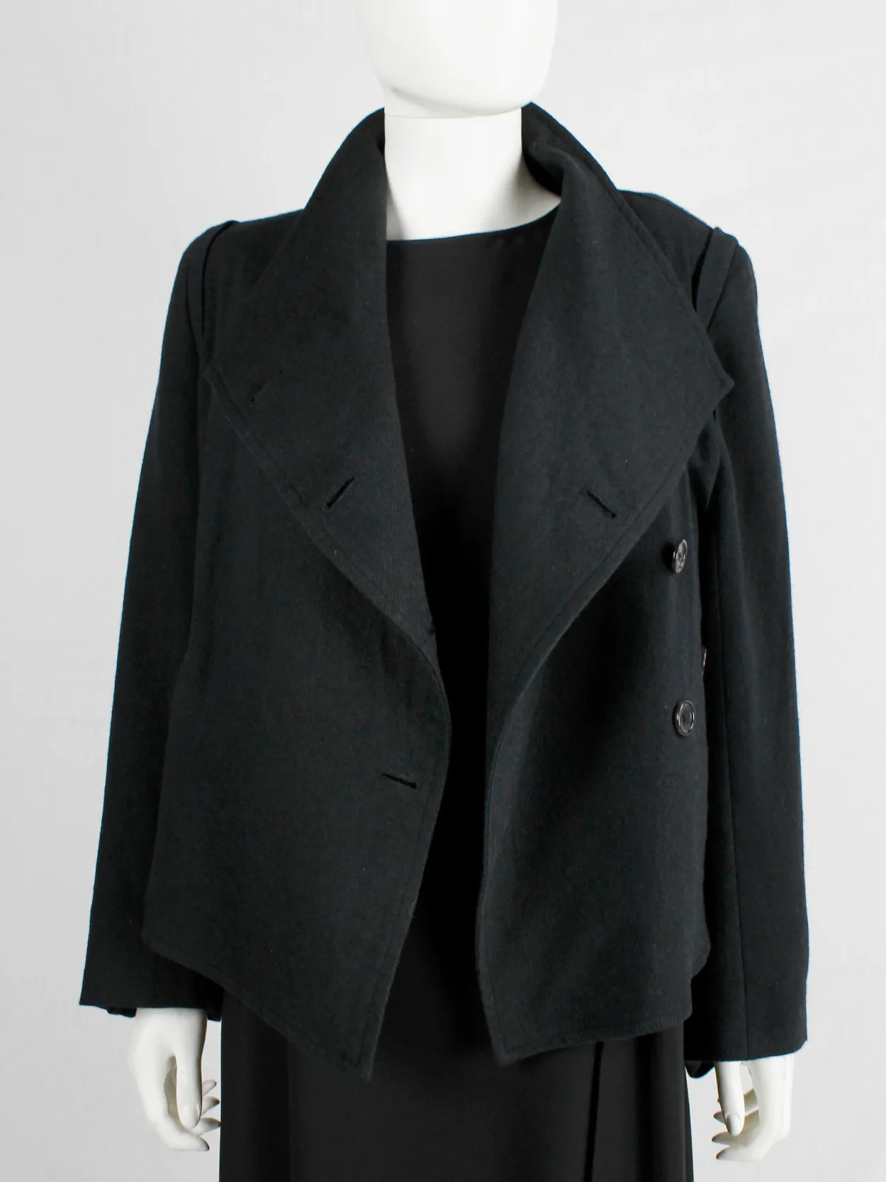 Ann Demeulemeester black coat with standing neckline and asymmetric button closure — fall 2010